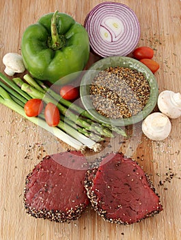 Raw steak with spices and vegetables