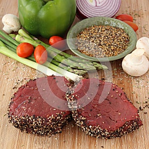 Raw steak with spices and vegetables