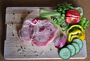 Raw steak with vegetables ready to be cooked on barbecure