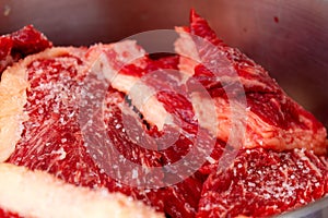 Raw steaks on a barbecue grill ready to grill