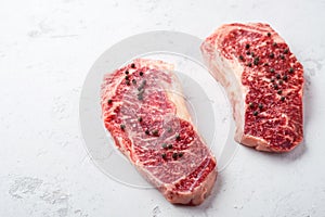 Raw Striploin beef steak on a white stone table