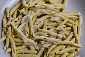 Raw strozzapreti, specialties from northern Italy, fresh twisted pasta that cooks very quickly and is suitable for chunky sauces