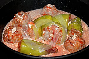 Raw stuffed peppers drenched in tomato and sour cream sauce