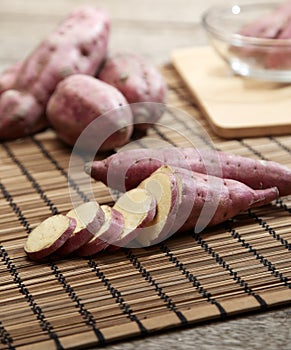 Raw sweet potato on wooden table