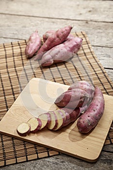 Raw sweet potato on wooden table