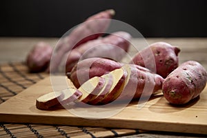 Raw sweet potato on wooden table