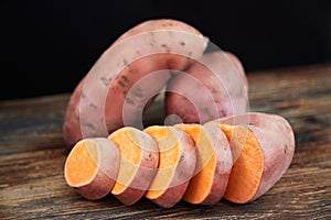 Raw sweet potatoes batatas on a rustic wooden table