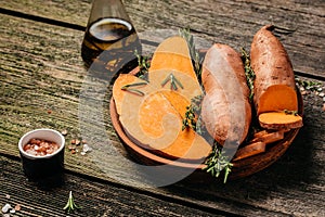 Raw sweet potatoes or batatas on wooden background. Food recipe background. Close up