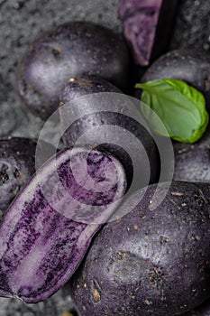 Raw sweet potatoes on dark background closeup. Batata potato. vegan food ingredient. vertical image. top view. place for text