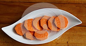 Raw sweet potatoes on wooden background closeup.Food concept.