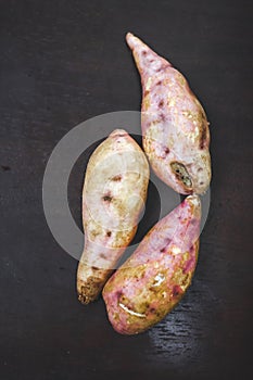 Raw sweet potatoes on wooden background closeup. sweet potato on wooden surface. Ipomoea batatas or Shakarkandi