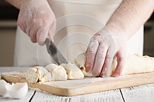 Raw sweet yeast dough on a baking sheet, filling buns raisin. Pr