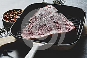 Raw T-Bone or porterhouse Steak in a grill pan ready to cooking