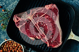 Raw T-Bone Steak seasoned in a grill pan ready to cooking