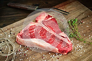 Raw t bone steak on wooden Board rustic style