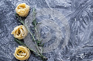 Raw tagliatelle nido on the flour-dusted black wooden background