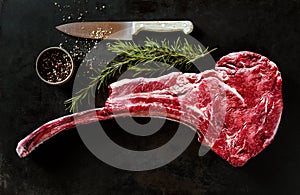 Raw tomahawk beef steak with ingredients