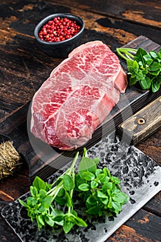 Raw Top Blade beef meat steak. Dark wooden background. Top view