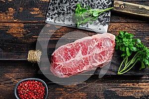 Raw Top Blade beef meat steak. Dark wooden background. Top view