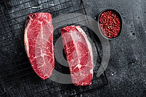 Raw top blade cut organic beef meat. Black background. Top View