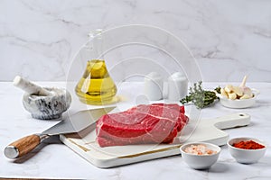 Raw top side beef steak on kitchen table