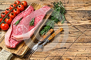 Raw top sirloin cap or picanha steak on a chopping Board. wooden background. Top view. Copy space