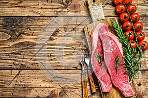 Raw top sirloin cap or picanha steak on a chopping Board. wooden background. Top view. Copy space