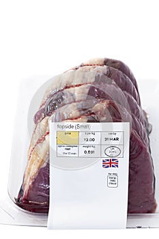 Raw topside of beef in plastic packaging with a food label sticker on the front.