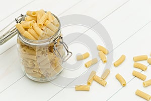 Raw tortiglioni pasta on a glass jar