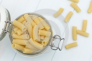 Raw tortiglioni pasta on a glass jar