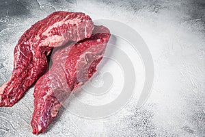 Raw tri tip beef steak on kitchen table. White background. Top view. Copy space