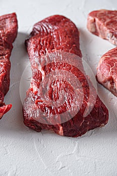 Raw  tri-tip  triangle  roast or bottom sirloin steak cut organic meat cut side view close up over white concrete background