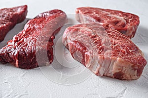 Raw tri-tip triangle roast or bottom sirloin steak near top blade cut organic meat cut side view close up over white concrete