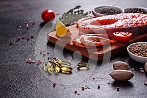 Raw trout red fish steak served with herbs and lemon and olive oil on a dark background