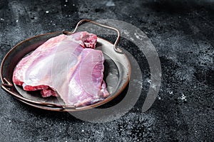 Raw Turkey boneless and skinless thigh fillet. Farm eco meat. Black background. Top view. Space for text
