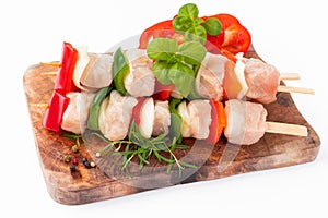 Raw turkey skewers with vegetables,peppers,onions white background.Skewers with pieces of raw meat,red, and green pepper