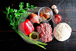 Raw Turkish Lahmacun Ingredients on a Dark Wood Background