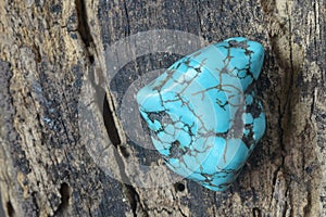 Raw turquoise gemstone rock isolated on wood