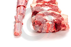 Raw uncooked beef oxtail cut into portions on white isolated background. Butcher craft. Meat industry product. Soup and stew