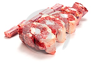 Raw uncooked beef oxtail cut into portions on white isolated background. Butcher craft. Meat industry product. Soup and stew