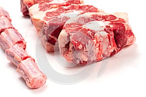 Raw uncooked beef oxtail cut into portions on white isolated background. Butcher craft. Meat industry product. Soup and stew