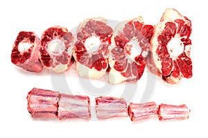 Raw uncooked beef oxtail cut into portions on white isolated background. Butcher craft. Meat industry product. Soup and stew