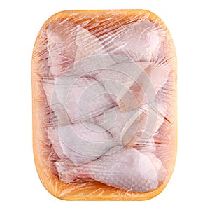 Raw and uncooked chicken drumsticks in a yellow plastic container. Meat of poultry in tray, isolated on white background. Top view