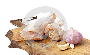 Raw uncooked chicken legs with garlic, drumsticks on wooden board