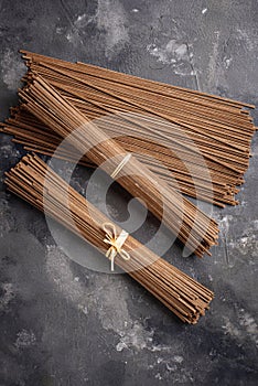 Raw uncooked Japanese soba noodles on grey bacground