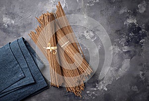 Raw uncooked Japanese soba noodles on grey bacground