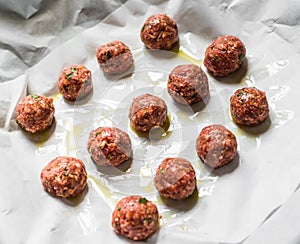 Raw uncooked meatballs on a baking sheet