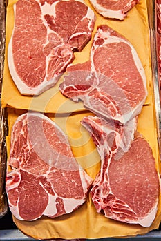 Raw, uncooked pork chops, pig meat, grocery store, meat department