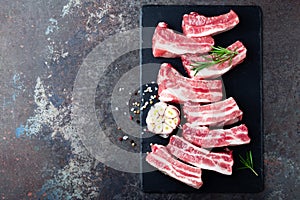 Raw uncooked pork ribs, fresh meat on dark metal background. Top view