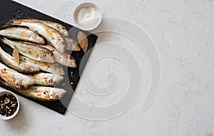 Raw uncooked  red mullets on gray background